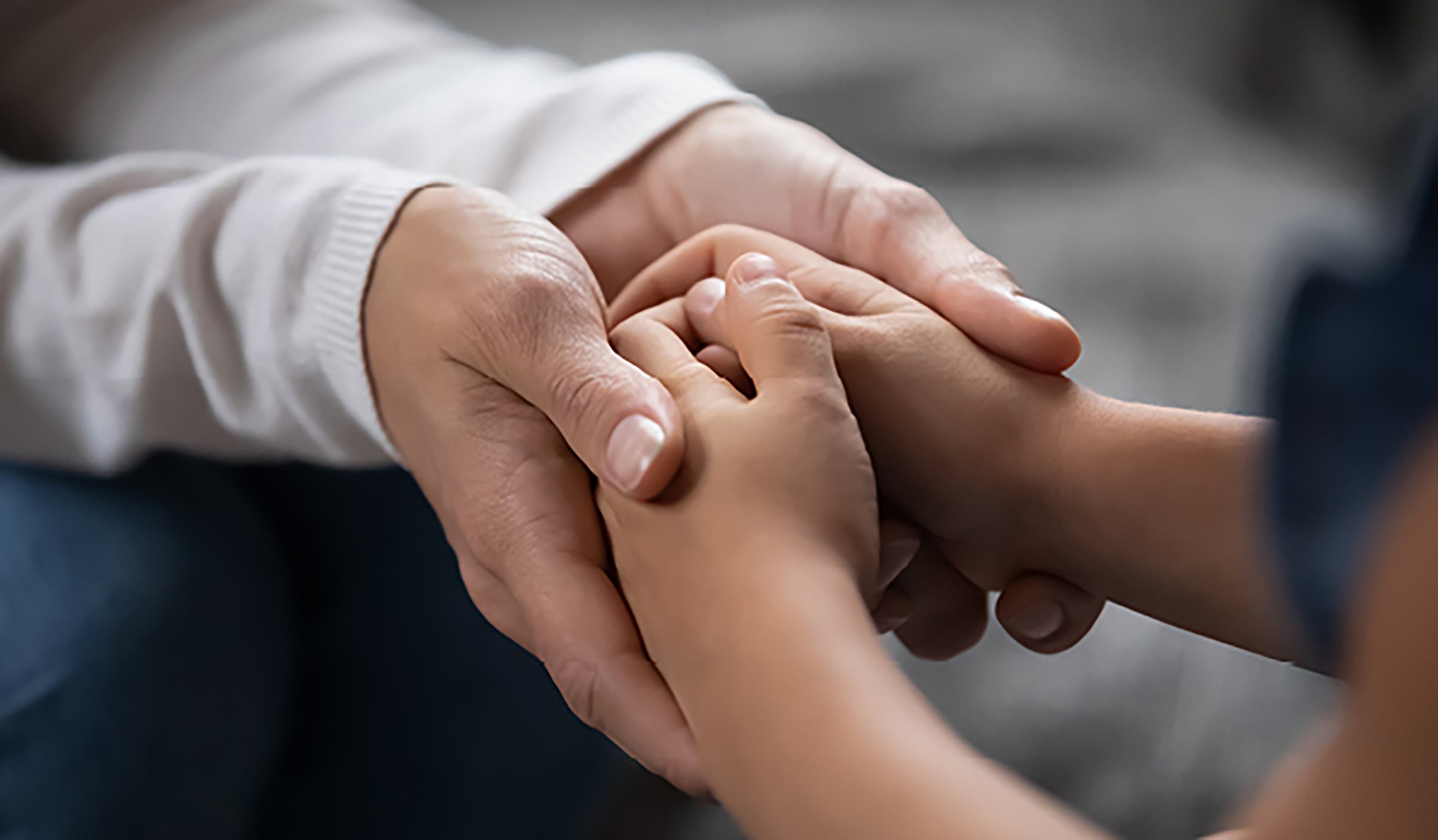 Adult holding child’s hands