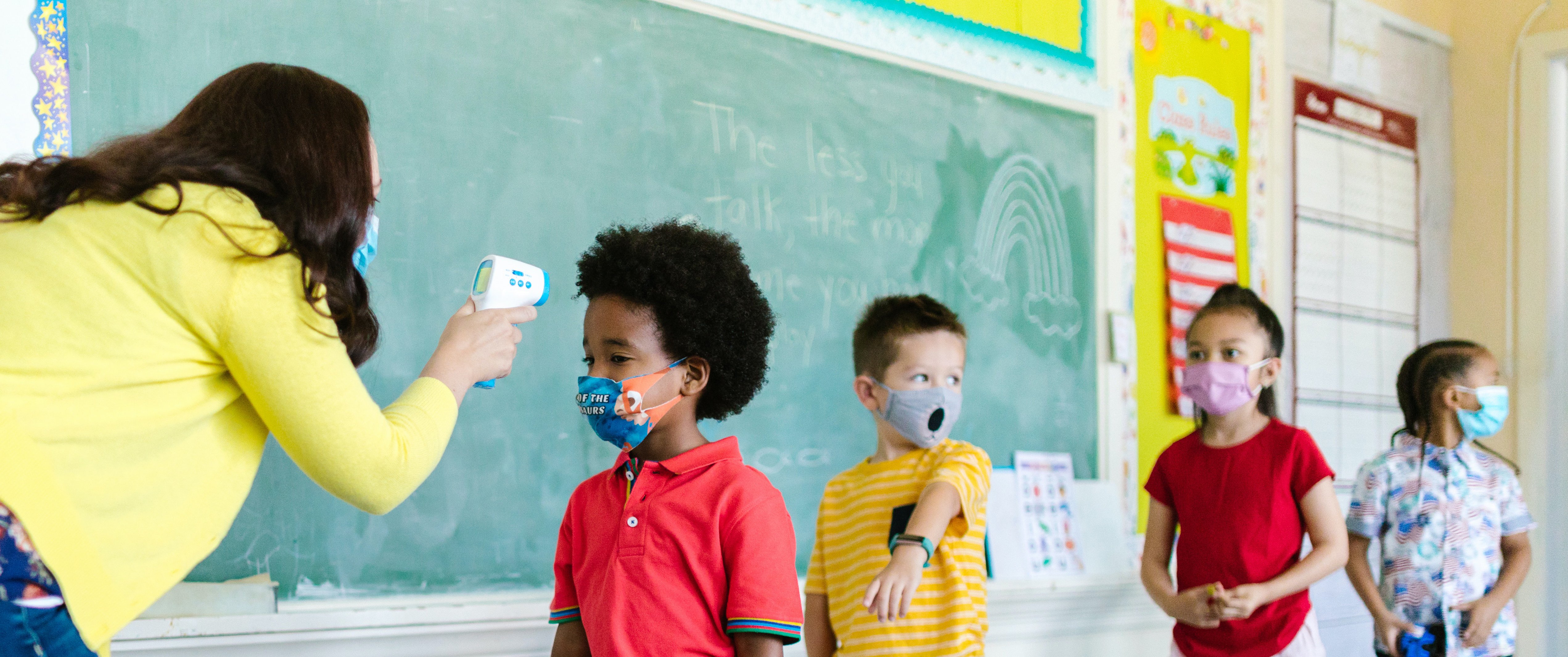 Teacher checking student temperature