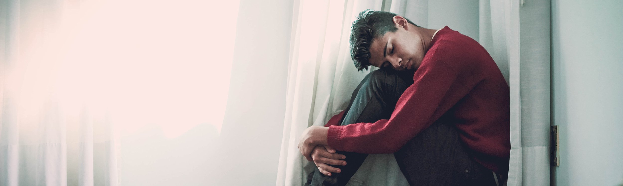 Young person huddled on floor
