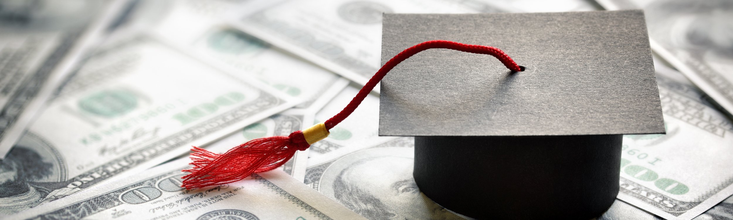 Graduation cap atop U.S. dollar bills