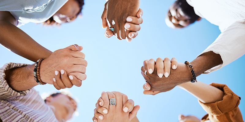A group of people holding hands in a circle.