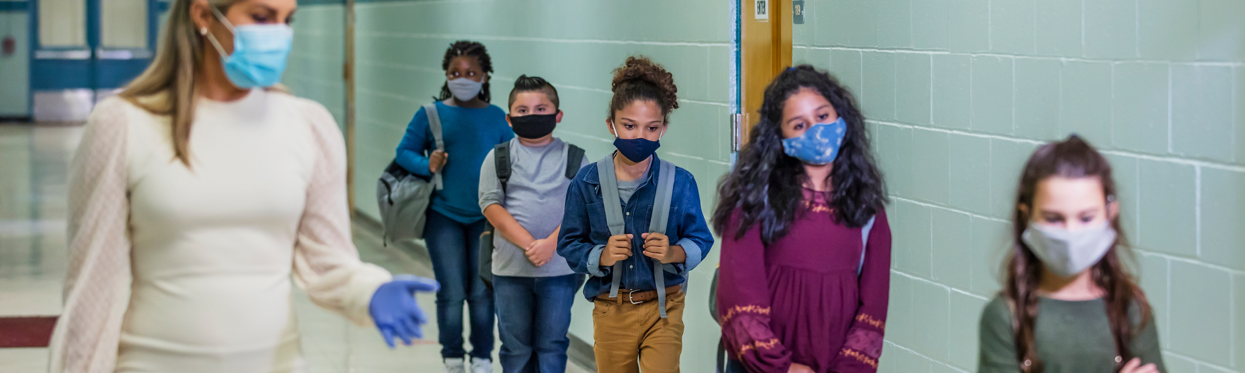 Students and teacher in school wearing masks