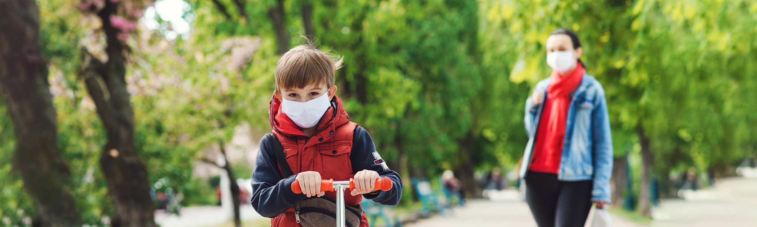 Child playing outside wearing mask