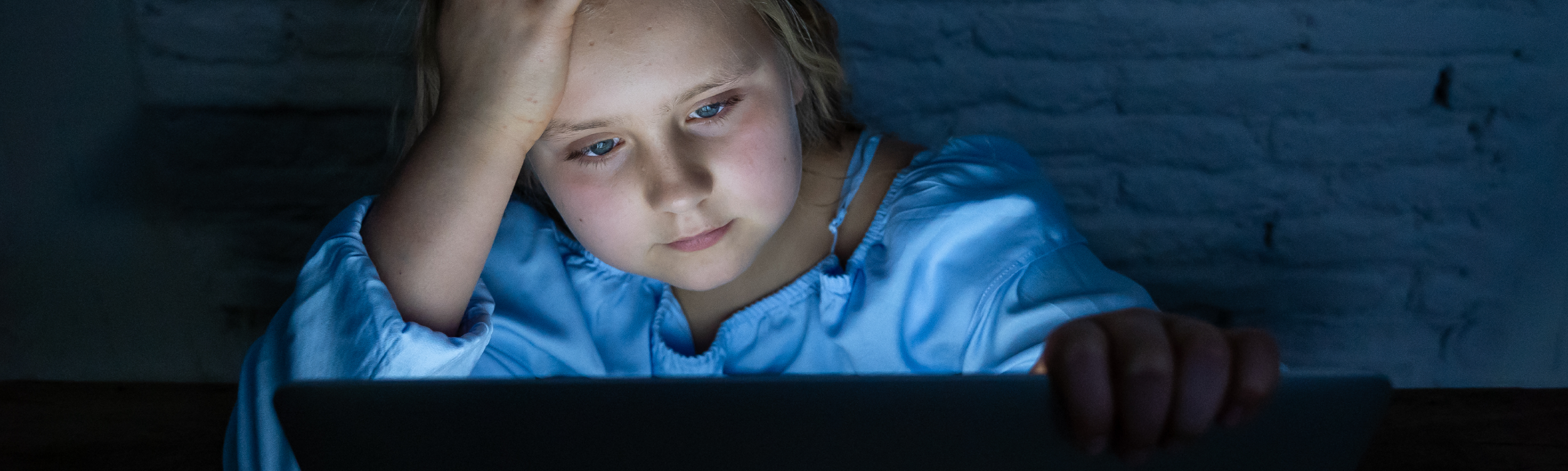 Child in dark room with computer