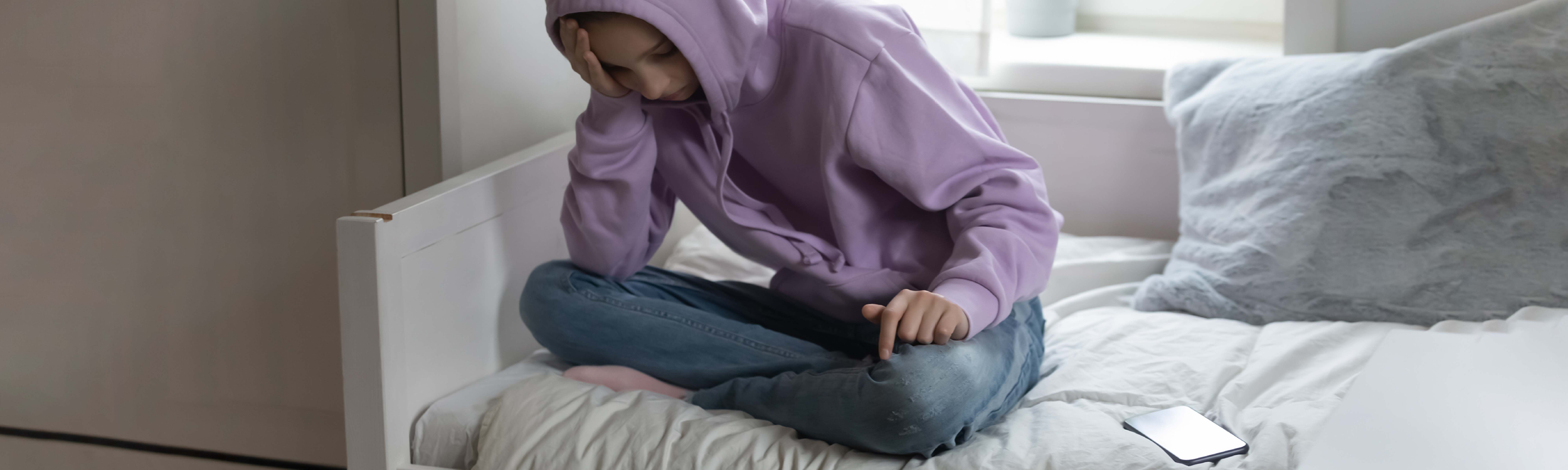 Student on bed with mobile device