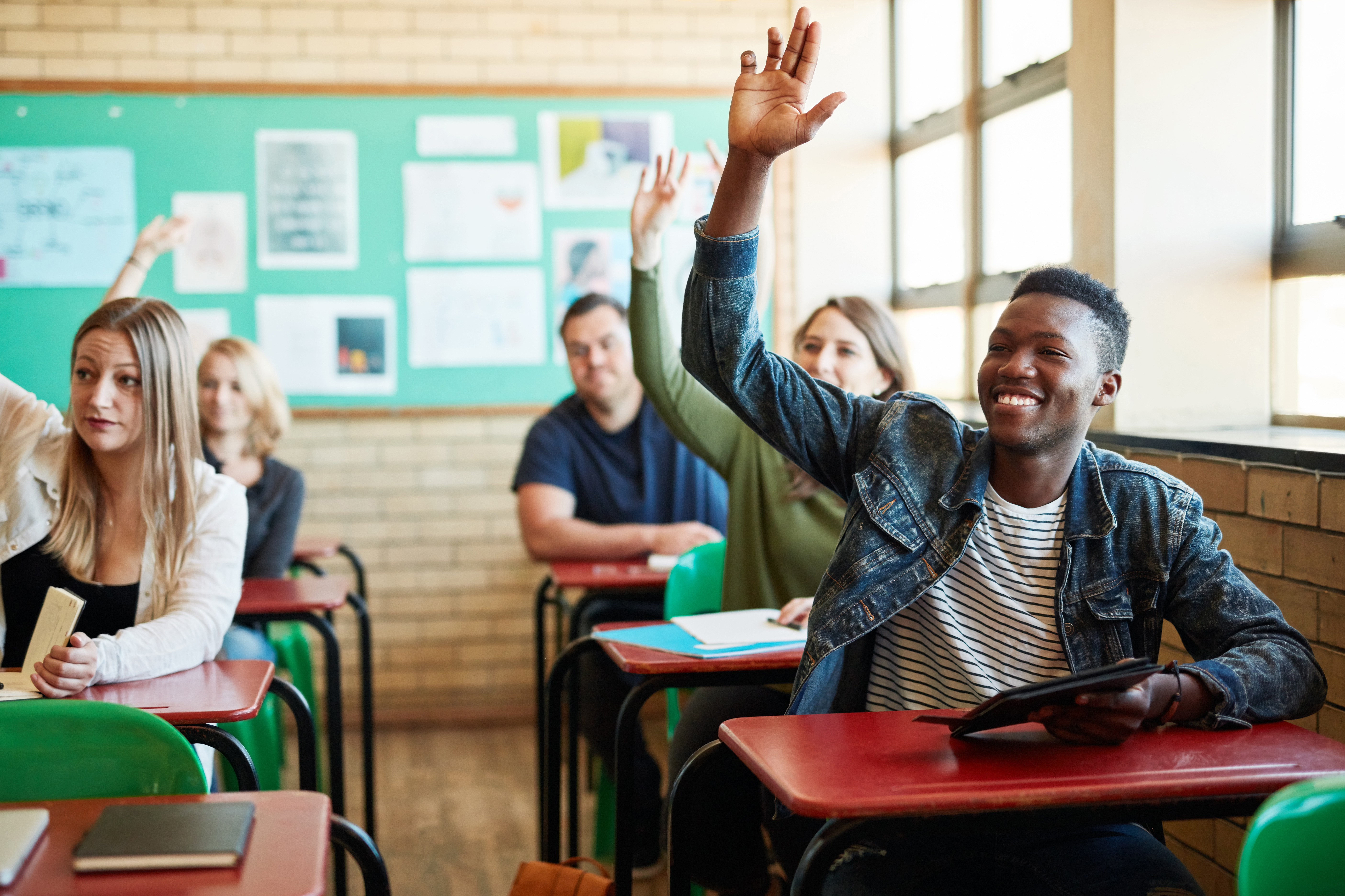 Students raising hands in classroom