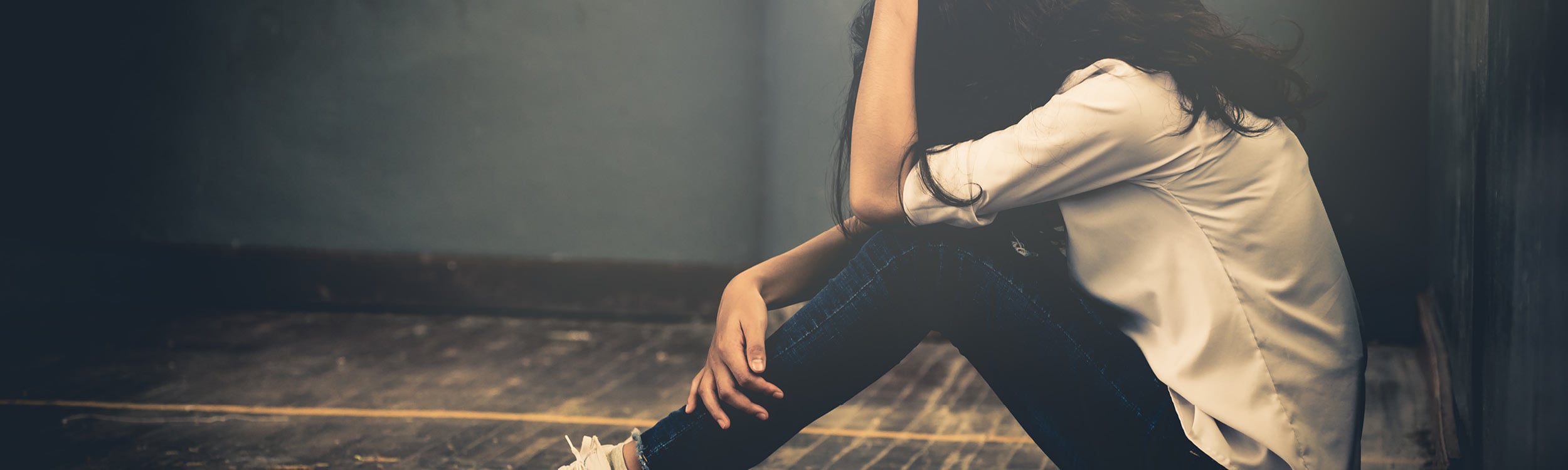 Young girl hunched over alone